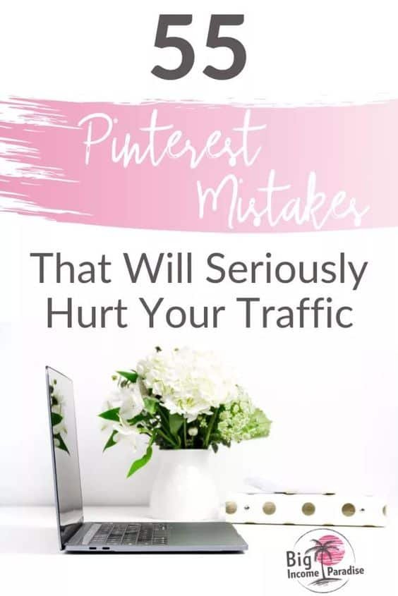 laptop on white desk with white flowers and a note book with gold dots